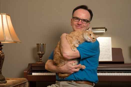 Participant Paul - person wearing a blue shirt holding a cat