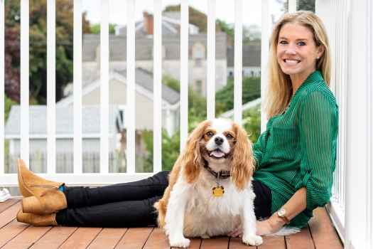Participant Jenni - person with long blond hair smiling and sitting outside with a dog