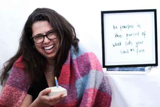 Participant Dayna - person with long and dark wavy hair and glasses smiling