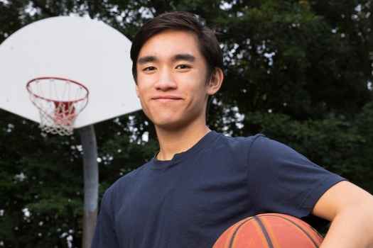 Participant Joel - person with short dark hair smiling outside with a basketball