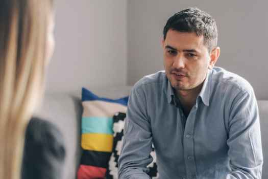 Person sits on couch talking to therapist