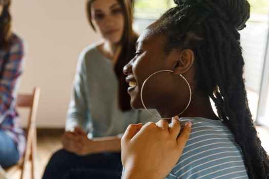 People sit in chairs in group therapy