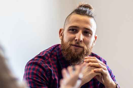 Person in plaid shirt talking to clinician