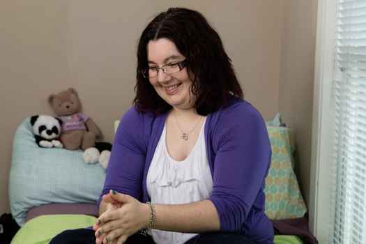 Participant Christina - person with shoulder length dark hair and glasses wearing a purple sweater