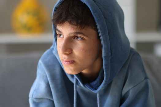 Young person in hoodie looking off