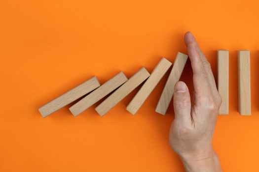 Hand between blocks on orange background