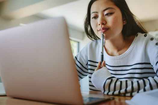 Young woman does schoolwork on laptop