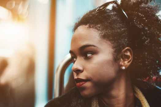 young black woman on subway looking out window