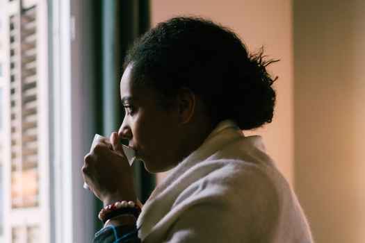 Woman sipping on coffee looking out the window