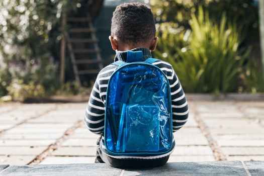 Child sitting with backpack