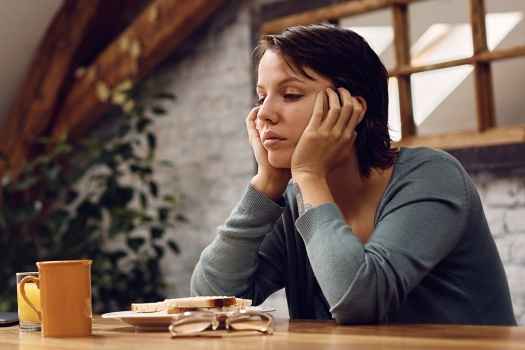 woman at a table looking sad
