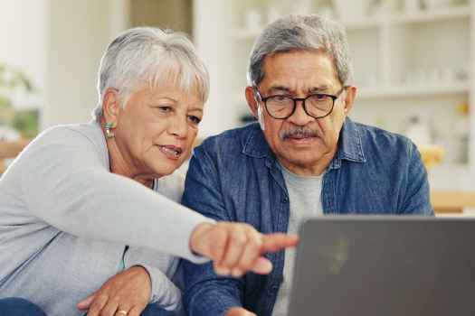 Senior couple at desk with laptop