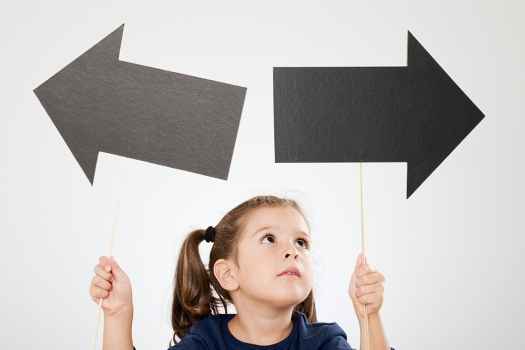 Child holding arrows pointing in different directions