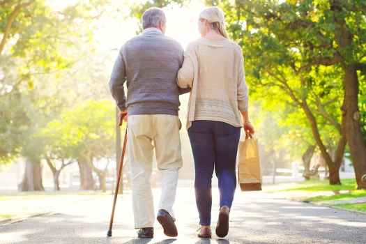 Older couple walks outside