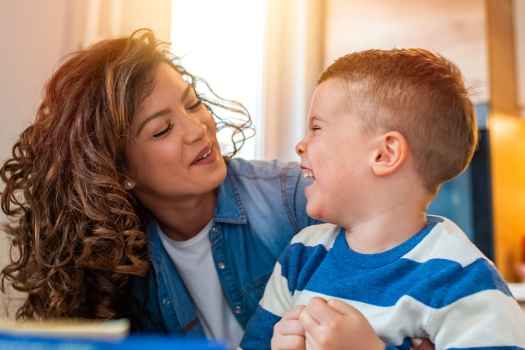 Caregiver and young child laugh together