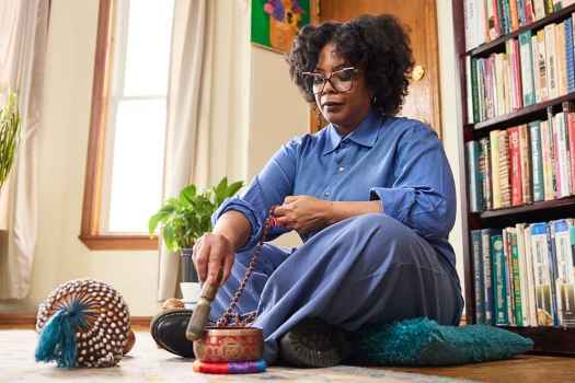 Deconstructing Stigma participant Johanne - person sits on floor in room with meditation bowl