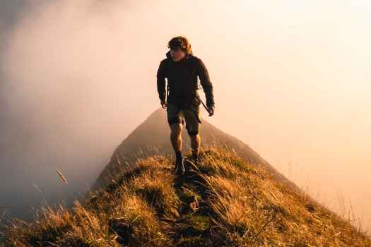 Hiker climbing and surrounded by clouds
