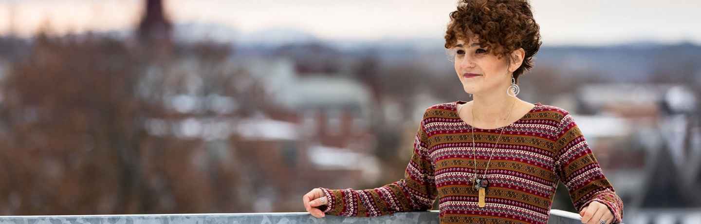 Participant Julia - person in red sweater leaning against a railing