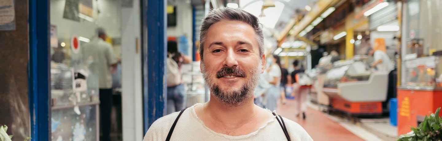 Deconstructing Stigma participant Shimon - person stands in fruit market