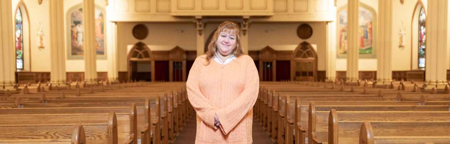 Participant Jodi - person with long auburn hair smiling in a church