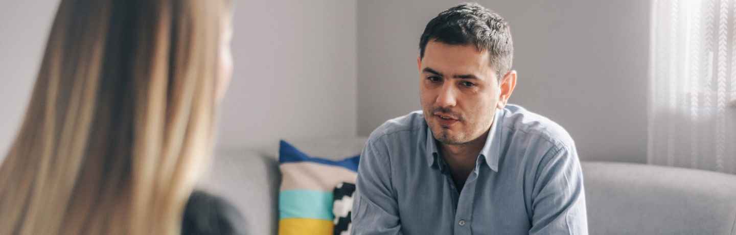 Person sits on couch talking to therapist