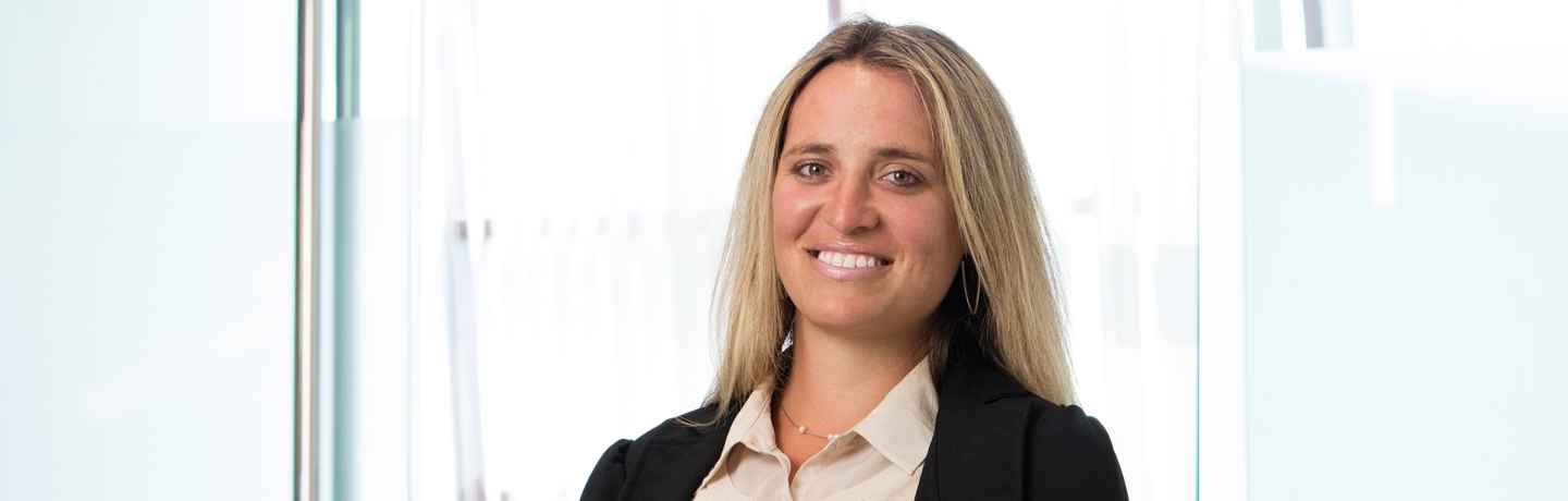 Deconstructing Stigma participant Jessica - person in business suit stands by glass wall