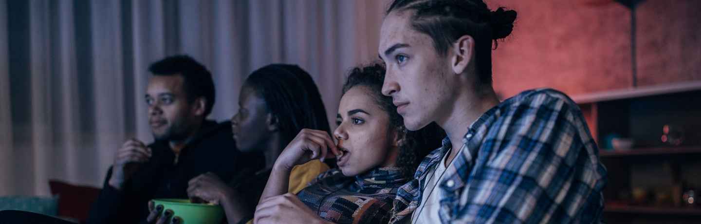 Teens watch movie, eat popcorn