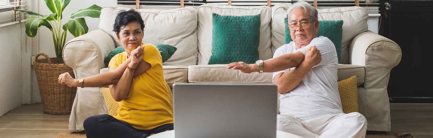 man and woman stretch in front of computer