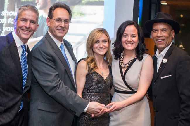 People smiling with an award