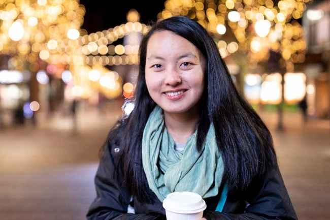 Participant Tian - person with dark hair holding a cup for a warm drink