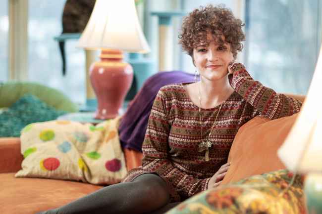 Participant Julia - person in red sweater sitting on an orange couch