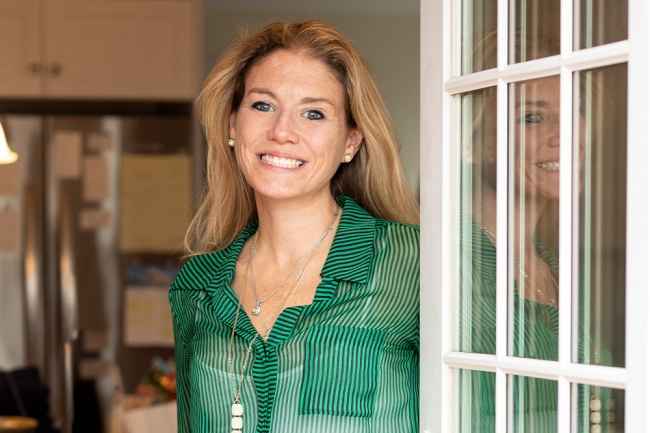 Participant Jenni - person with long blond hair smiling in a doorway