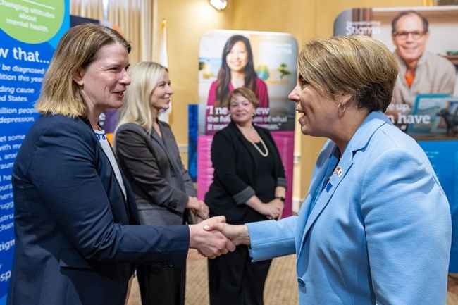 Shaking hands with Governor with poster panels on display