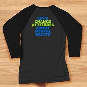Back of a dark grey shirt that says Let’s change attitudes about mental health