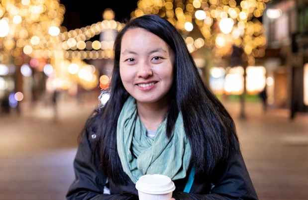 Participant Tian - person with dark hair holding a cup for a warm drink