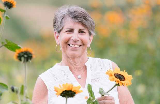 Participant Linda - person with short hair in a field of sunflowers