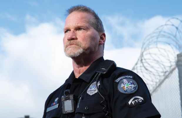 Participant Kevin - person in police uniform in front of a bright blue sky with clouds