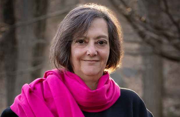 Participant Elissa standing outside wearing a black sweatshirt and a pink scarf