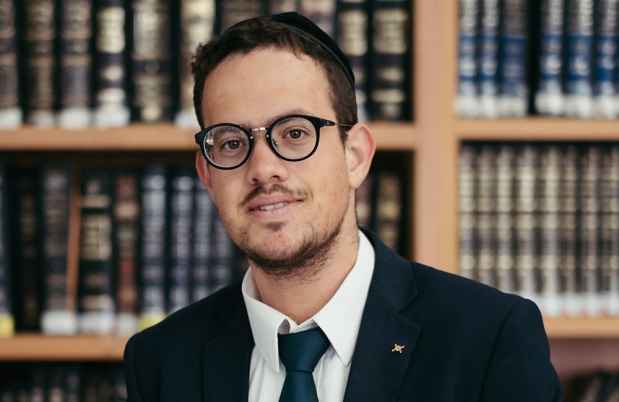 Deconstructing Stigma participant David - Person stands in front of shelves of books