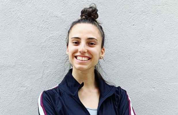 Participant Diana standing and smiling with her arms folded