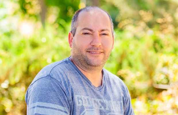 Deconstructing Stigma participant Eitan - person sits outside green plants in the background