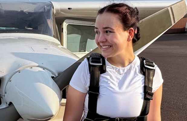 Participant Daria standing in front of a propeller plane