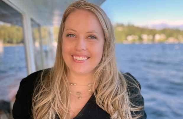 Participant Melissa - person with long blond hair smiling in front of a body of water