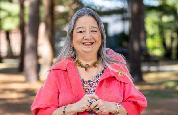 Participant Pata - person with long grey hair smiling outside