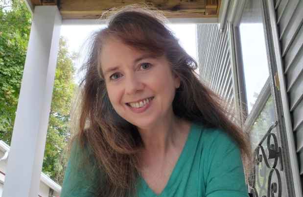 Participant Phyllis - person with long light brown hair smiling outside