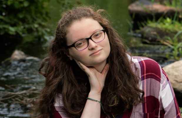 Participant Molly - person with brown wavy hair and glasses outside