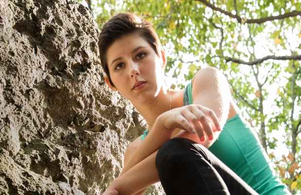 Participant Sonya - person with short dark hair on a large rock