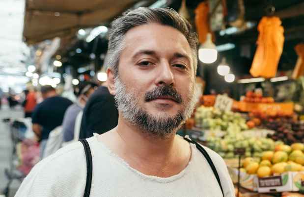 Deconstructing Stigma participant Shimon - person stands in fruit market