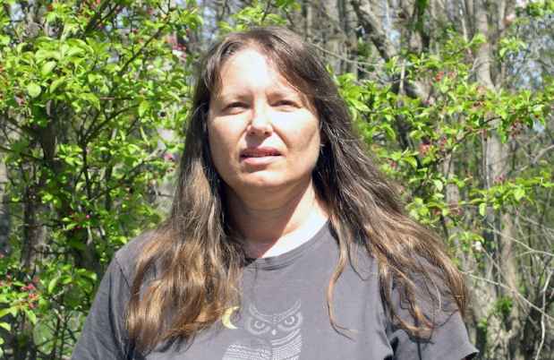 Participant Shirley - person with long dark hair in front of greenery outside