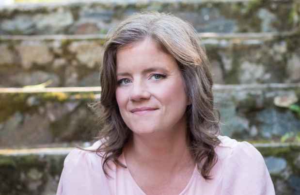 Participant Theresa - person with wavy brown hair sitting on stone steps